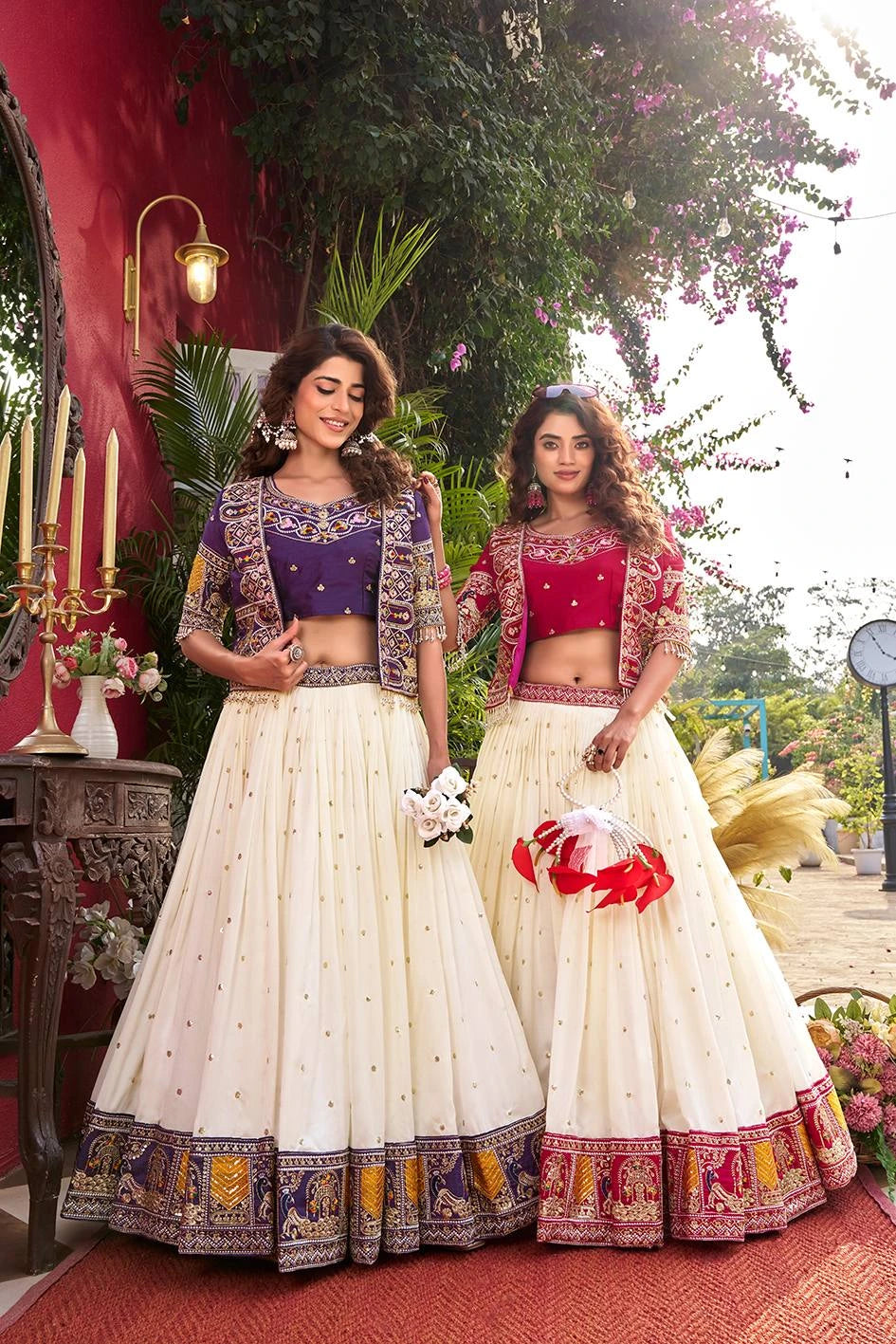 Two women in traditional Indian attire standing outdoors with decorative elements.